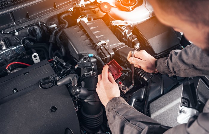 Auto technician safely disconnecting car battery